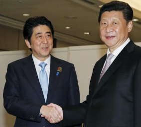 Japan's Prime Minister Shinzo Abe, left shakes hands with China's President Xi Jinping on Wednesday.