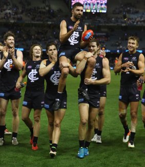 Simpson is chaired off by teammates after playing his 250th game in 2016. 