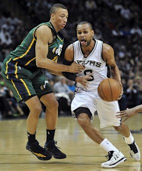 San Antonio Spurs guard Patty Mills, right, of Australia, drives around Utah Jazz guard Dante Exum, also of Australia, during the first half of an NBA basketball game, Sunday, Jan. 18, 2015, in San Antonio.