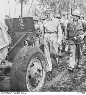 General MacArthur walks behind a field gun with American troops near Japanese-held Hollandia in Dutch New Guinea in April 1944 