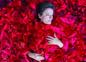 Megan Evans lies in a sea of ribbons in This Wild Song. 
