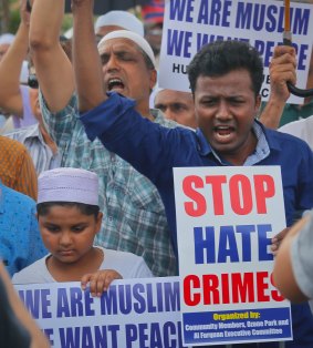 Mourners hold signs protesting the killings of imam Maulama Akonjee and Thara Uddin during funeral services for both men.