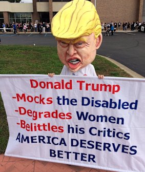 Tom Moran of Fenton wears a large Donald Trump head at The Dow Event Center in Saginaw, Michigan.