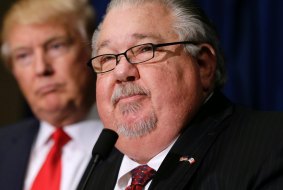 Sam Clovis speaks during a news conference as then-Republican presidential candidate Donald Trump, left, watches before a campaign rally in Dubuque, Iowa. 