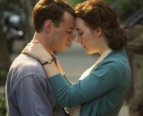 Emory Cohen as Tony and Saoirse Ronan as Eilis embrace in <i>Brooklyn</i>.