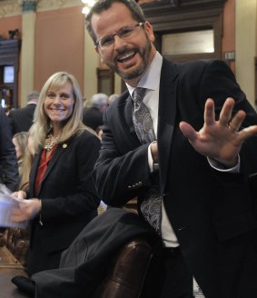 Cindy Gamrat and Todd Courser wave to reporters in the House of Representatives in Lansing. 