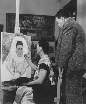 Diego watches Frida paint a self-portrait (1940).
