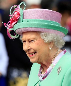 Queen Elizabeth II wearing a pink and green outfit.