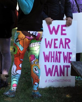 A woman joins others gathering at a starting point before marching for "yoga pants parade".
