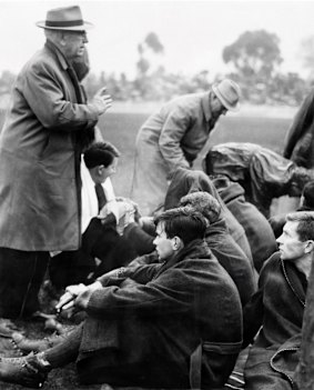 Demon coach Frank 'Checker' Hughes talks to Melbourne players.