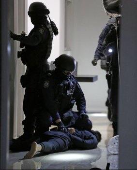Osama Hawat is forced to the ground at his Greenacre home on Thursday morning.