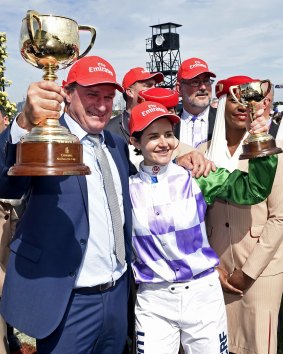 Prince Of Penzance jockey Michelle Payne, right, with trainer Darren Weir, left, hold the winning trophies after the Melbourne Cup at Flemington on Tuesday.