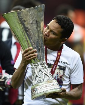 Sevilla's forward Carlos Bacca celebrates with the trophy.