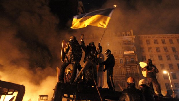 Flying the flag: Anti-government protesters clash with riot police in Kiev on Friday night.
