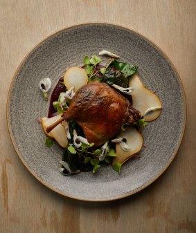Confit duck leg with pears and broad bean flowers.