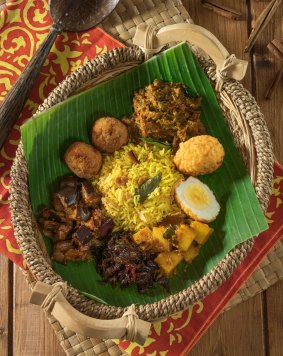 Lamprais: Rice (cooked in rich stock), plus one or two meat or vegetable curries, a spiced meatball (sometimes replaced with a fish cutlet), a boiled egg, some eggplant sambal and coconut belacan, all wrapped in a banana leaf.
