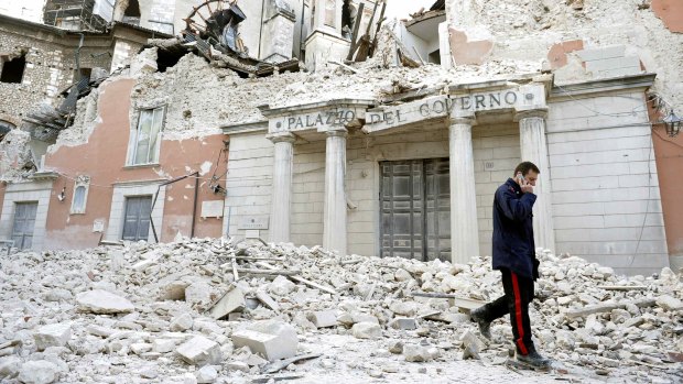 A police officer walks past ruined government buildings in L'Aquila in April 2009.