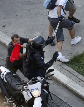 Anti-austerity demonstrators tussle with a motorcycle policeman in Syntagma Square in Athens.