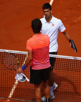 Game, set and match: Novak Djokovic shakes hands at the net with Thanasi Kokkinakis.