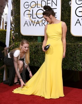 Sophie Turner fixing her Game of Thrones co-star star and BFF Maisie Williams's dress.