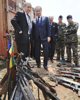 French President Francois Hollande, second from left, and French Defence Minister Jean-Yves Le Drian, left, inspect weapons confiscated by the French military during operation Sangaris, Central African Republic. 