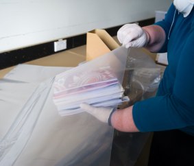  Sarah Lethbridge senior archivist demonstrates how to package the books for freezing. 