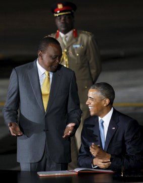 Kenya's President Uhuru Kenyatta (L) stands while US President Barack Obama signs a guest book at Jomo Kenyatta International Airport in Nairobi on Friday.