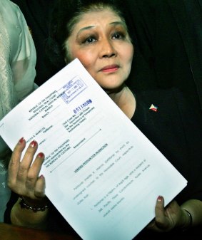  Imelda Marcos shows her petition for injunction to prevent the government from selling her seized jewellery in Manila in 2005. Marcos had vowed to stop its auction by Christie's .