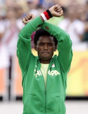 Silver medallist Feyisa Lilesa repeated his protest on the podium.