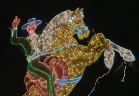 An illuminated cowboy is one of the many signs to appear in the film.
