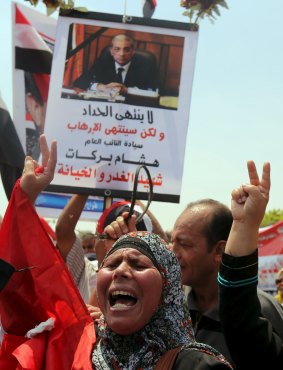 A woman holds up a portrait of Egyptian public prosecutor Hisham Barakat at his funeral on Tuesday.
