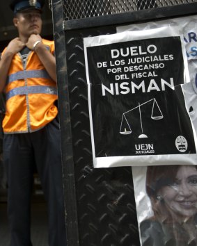 A police officer stands guard in front of the prosecutor's, where a sign is posted about the staff mourning the death of Alberto Nisman.