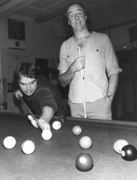 John Clarke, creator of sociological commentator Fred Dagg, right, plays pool with 2JJ morning disc jockey Bob Hudson in 1979. 