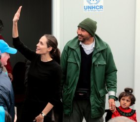 Angelina Jolie waves during her  visit to the temporary refugee facilities at the port of Piraeus.