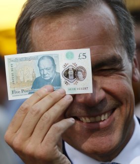 Bank of England governor Mark Carney with Britain's new polymer five-pound note.