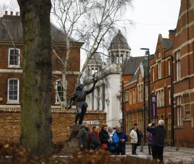 Visitors have their photograph taken in front of the King Richard III statue in Leicester.