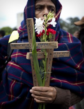 An indigenous woman holds wooden crosses and flowers on the National Day of Dignity for the Victims of Armed Internal Conflict in Guatemala City last week.