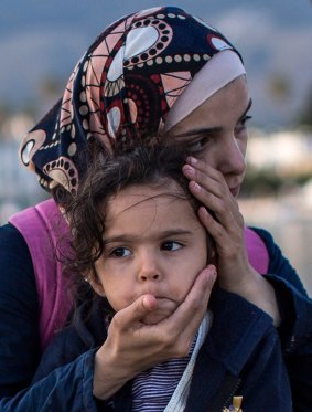 A Syrian woman embraces her daughter on the Kos dockside after being escorted into the harbour by the Greek coastguard.