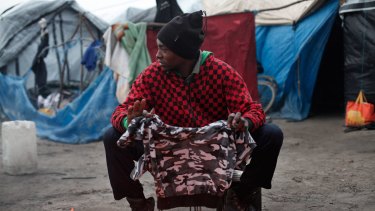 A migrant dries his clothes above a fire, in the migrant camp of Calais, northern France, earlier this month. 