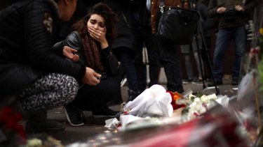 A woman places flowers near the scene of the Bataclan Theatre terrorist attack.