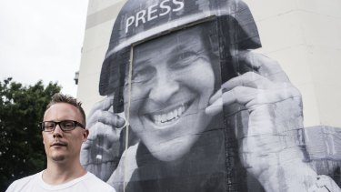 Street artist Hego with a paste up he did of jailed Journalist Peter Greste. 