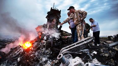 People inspect the crash site of Malaysia Airlines MH17. Russian propaganda 'trolls' have tweeted falsely that the Ukraine military shot the plane down.