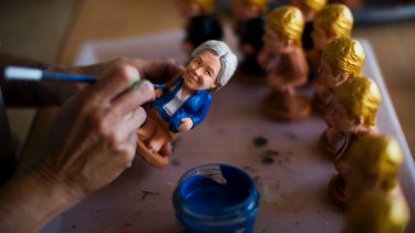 An artisan paints clay miniatures of Hillary Clinton in a "caganer" factory at Torroella de Montgri, north-east of Catalonia, Spain.