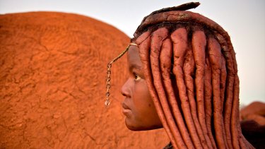 Women of Himba tribe have braids swept back in red plaits covered with Otjize, a mixture of butterfat and ochre.
