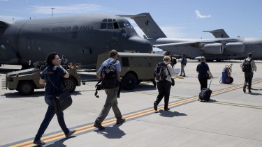 Personnel from the Australian Defence Force and Department of Foreign Affairs and Trade depart RAAF Amberley.