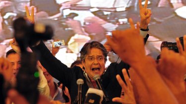Guillermo Lasso flashes victory signs as he awaits final election results in Guayaquil, Ecuador, on Sunday.