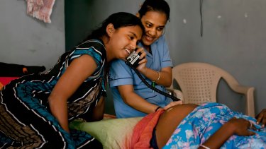A nurse and a surrogate mother listen to a baby's heartbeat in a dormitory run by Akanksha Clinic, in Anand, India prior to India's ban last year.