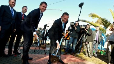 Digging in: Mike Baird and Tony Abbott turn the first sods on the Kings Georges Road and M5 interchange upgrade. 