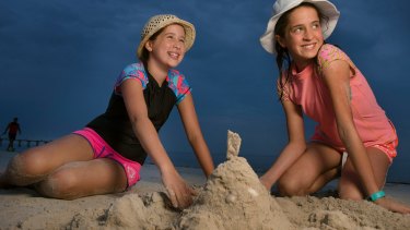 Zoe Bueti (left) returns to the beach with her sister Christina  after being badly sunburnt by an ineffective spray-on sunburn cream.