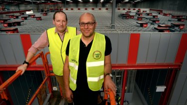 Catch Group head of logistics Jon Northorpe (left) and founder Gabby Leibovich on a cherry picker overseeing the company's $20 million investment in warehouse robots.